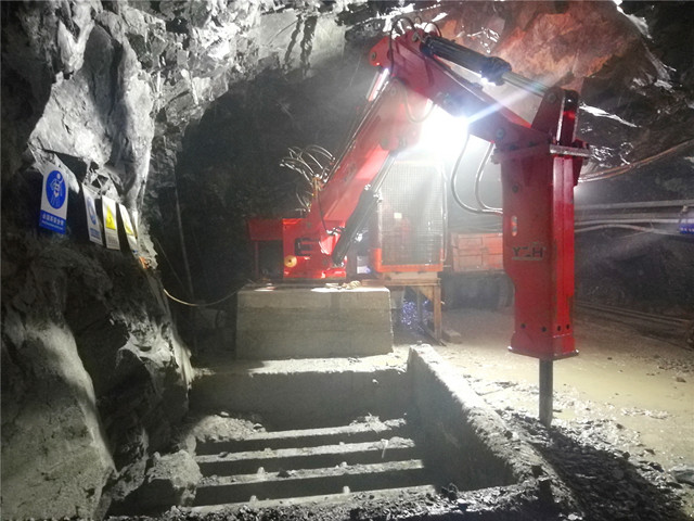 Пьедестал Rock Breaker Boom System разбивает большие камни под подземной шахтой